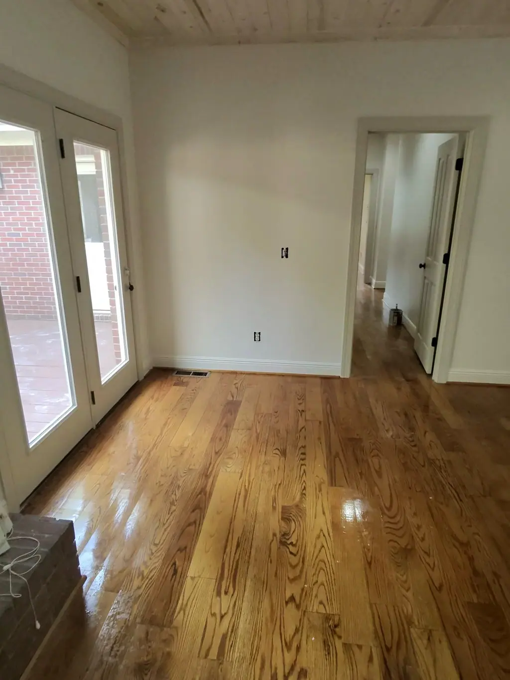 Empty room with hardwood floors and French doors after a move-out clean